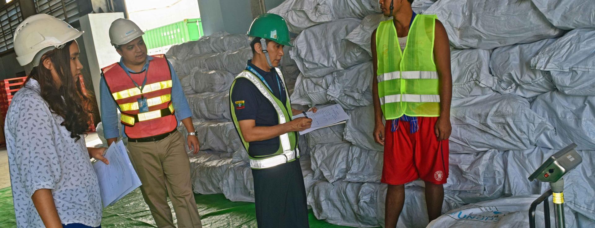 UNOPS-PR logistics team note the weights of LLIN bales as part of the inspection. Photo: UNOPS