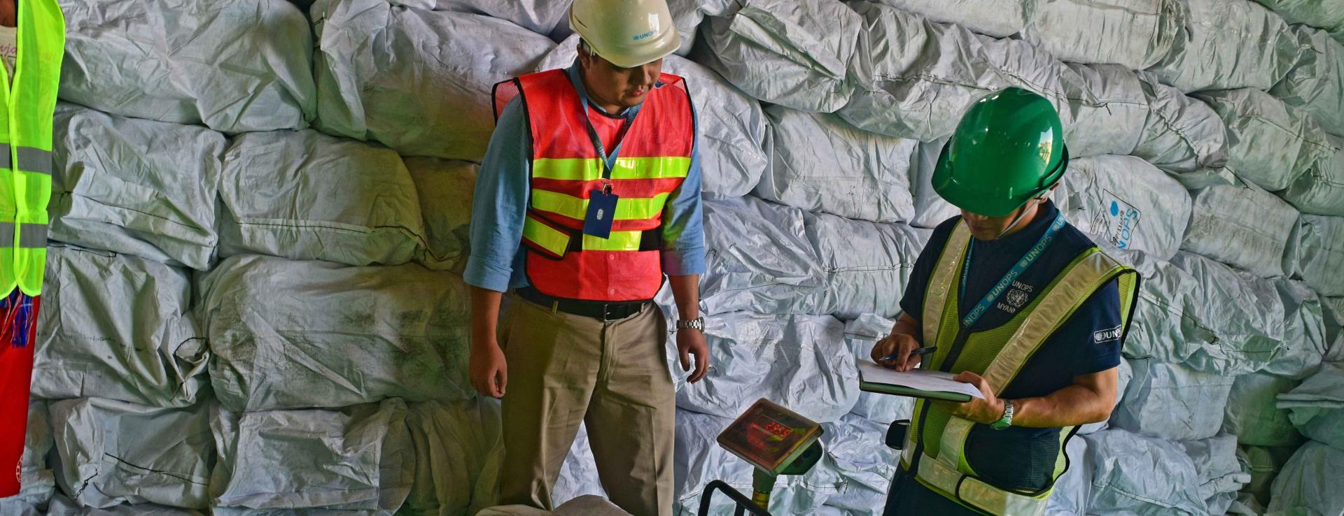 UNOPS-PR logistics team note the weights of LLIN bales as part of the inspection. Photo: UNOPS