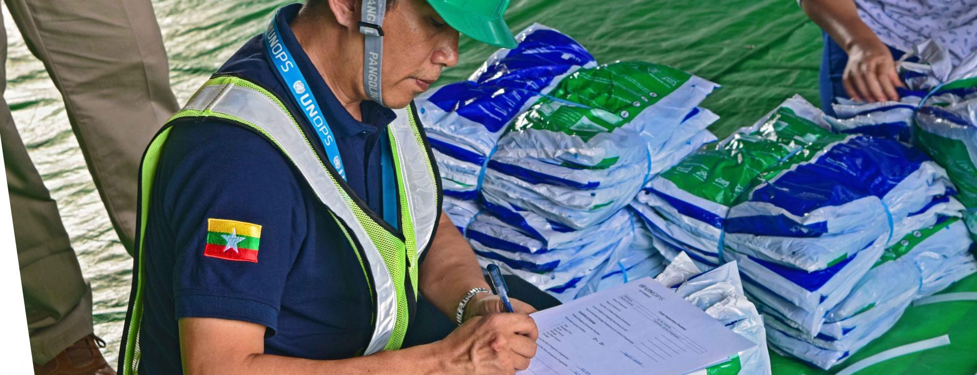 UNOPS-PR Logistics Analyst Ko Thiha Soe records LLIN inspection findings. Photo: UNOPS
