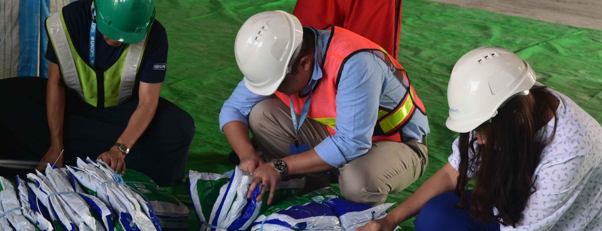 UNOPS-PR logistics team checks LLIN packages as part of the inspection. Photo: UNOPS