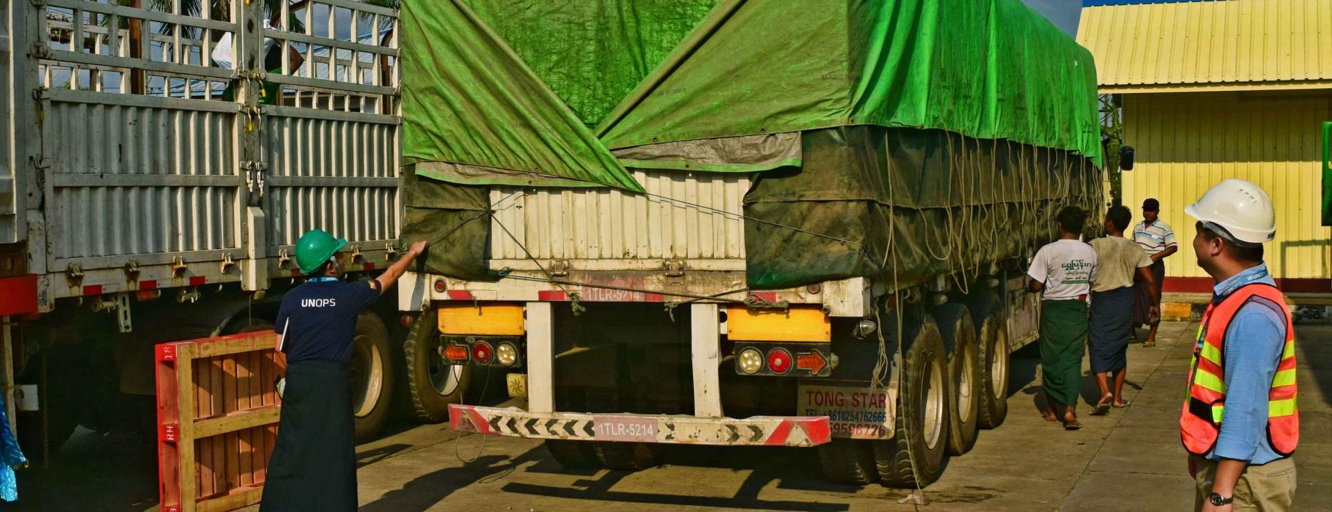 UNOPS-PR logistics team makes sure that LLINs are properly loaded for safe delivery, including tarpaulin covering to protect LLIN bales from rain and sun damage on the way. Photo: UNOPS
