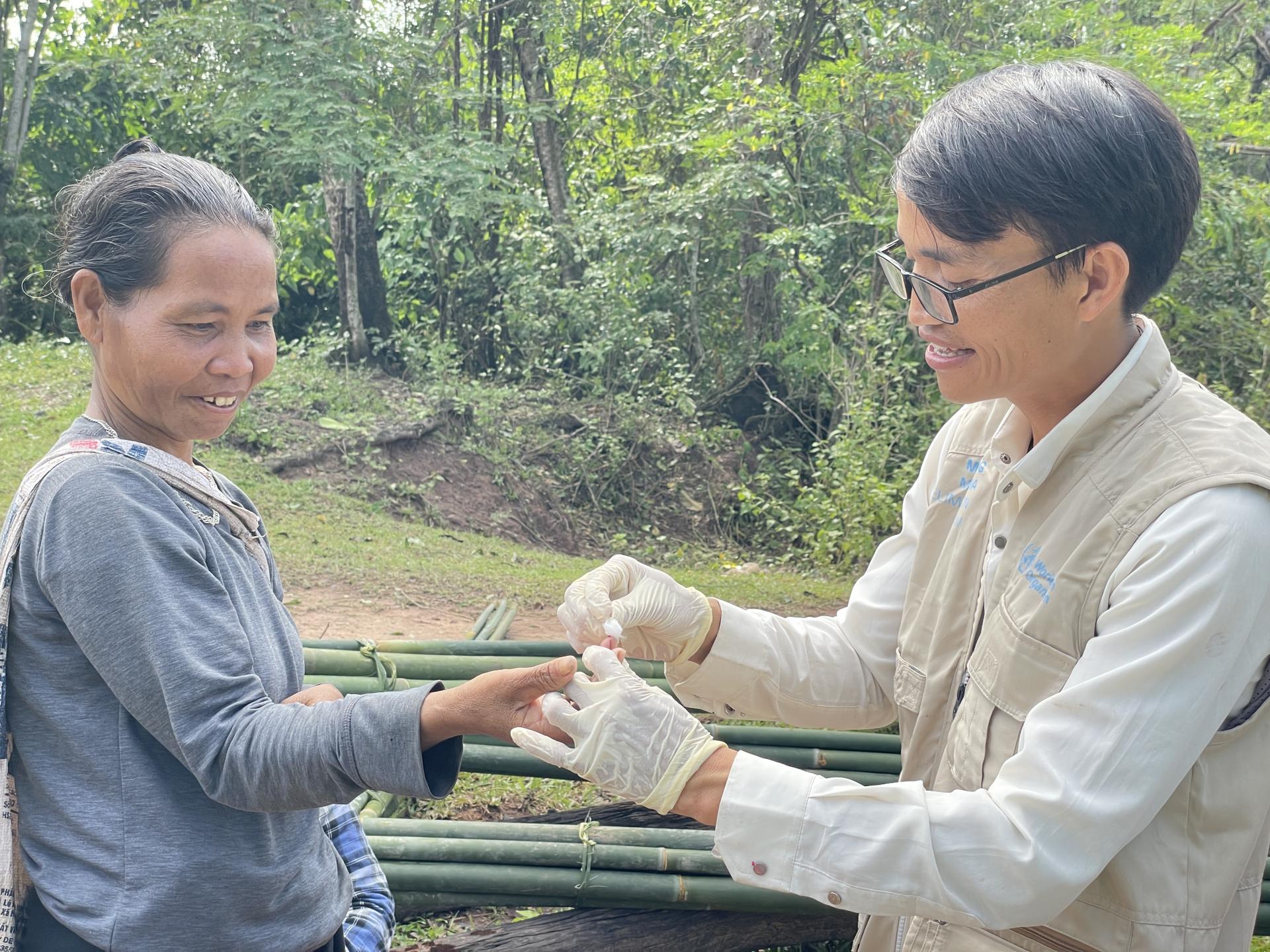 Volunteer malaria worker Ho Van Than draws a blood sample from a forest-goer to perform a malaria rapid diagnostic test in Xy Commune, Viet Nam. Photo: HPA Volunteer malaria worker Ho Van Than draws a blood sample from a forest-goer to perform a malaria rapid diagnostic test in Xy Commune, Viet Nam. Photo: HPA
