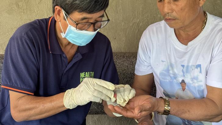 A Mobile Outreach Team (MOT) member conducts a malaria test for Nguyen Van Phuc during a routine follow-up visit to ensure his continued health and prevention. Photo: HPA 